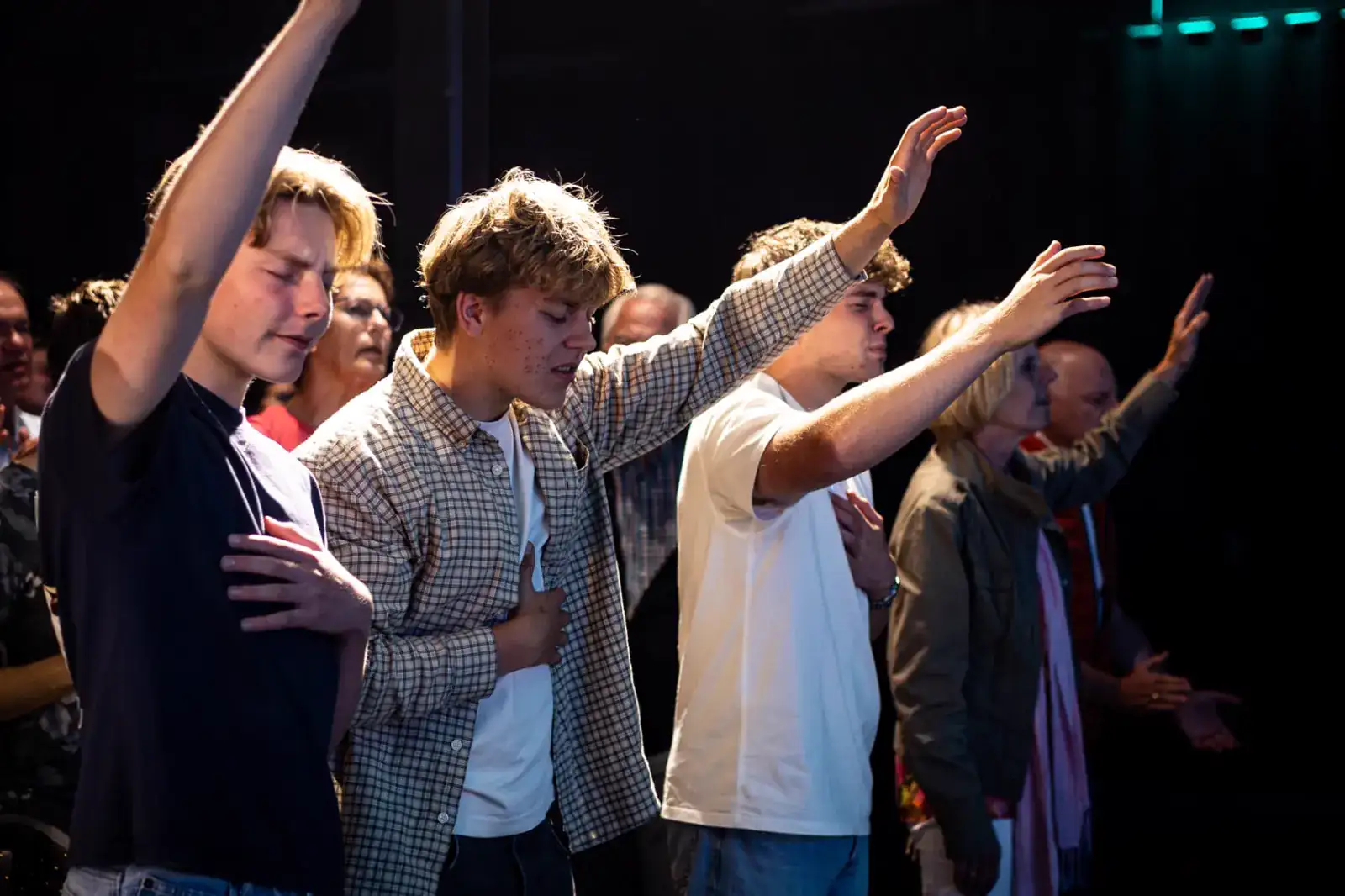 Bezoekers met opgeheven handen in aanbidding tijdens een Holy Spirit Night